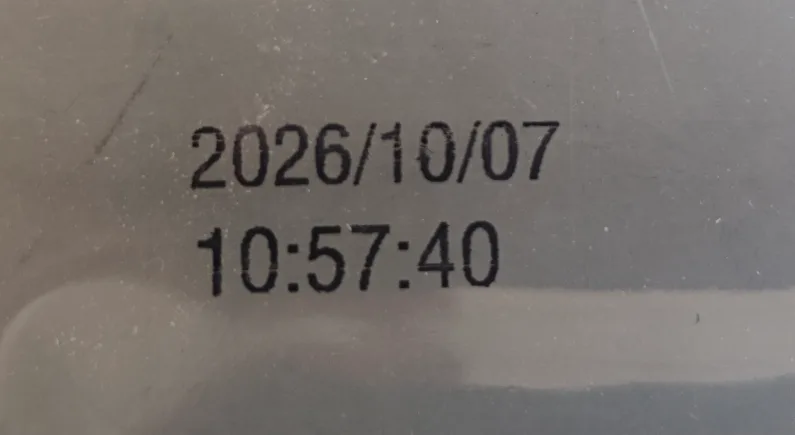 A thermal inkjet date code printed on the curved, glossy surface of a flexible pouch