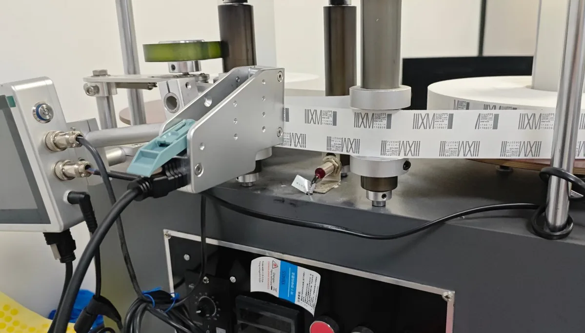 A solvent TIJ cartridge mounted in a printhead on a packaging machine, printing the same mark repeatedly along a white web